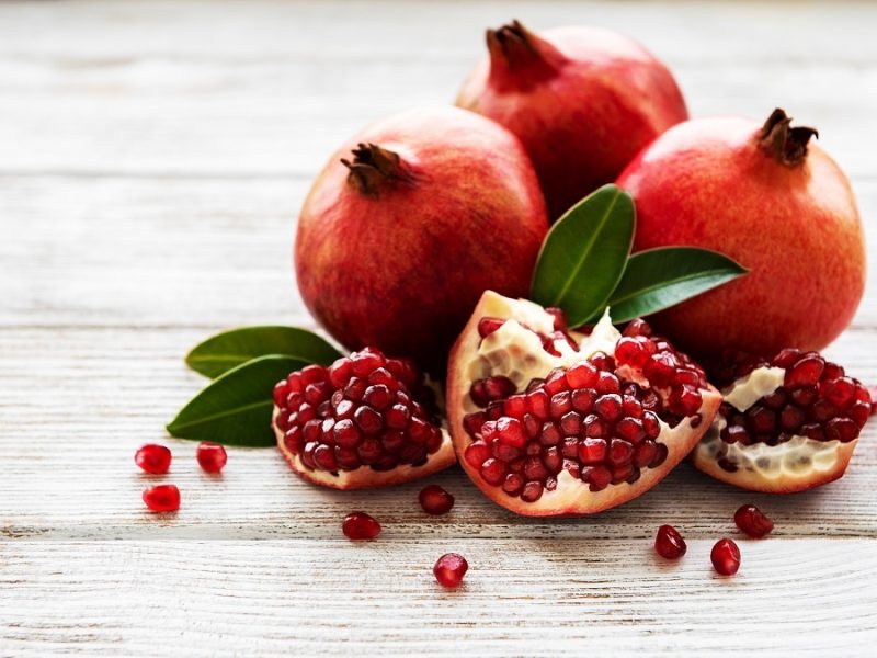 Ripe pomegranate fruits on  wooden vintage background